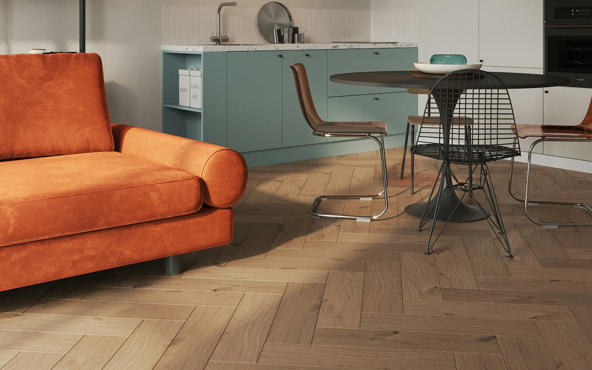 Appartement rénové avec canapé orange et parquet en chevrons