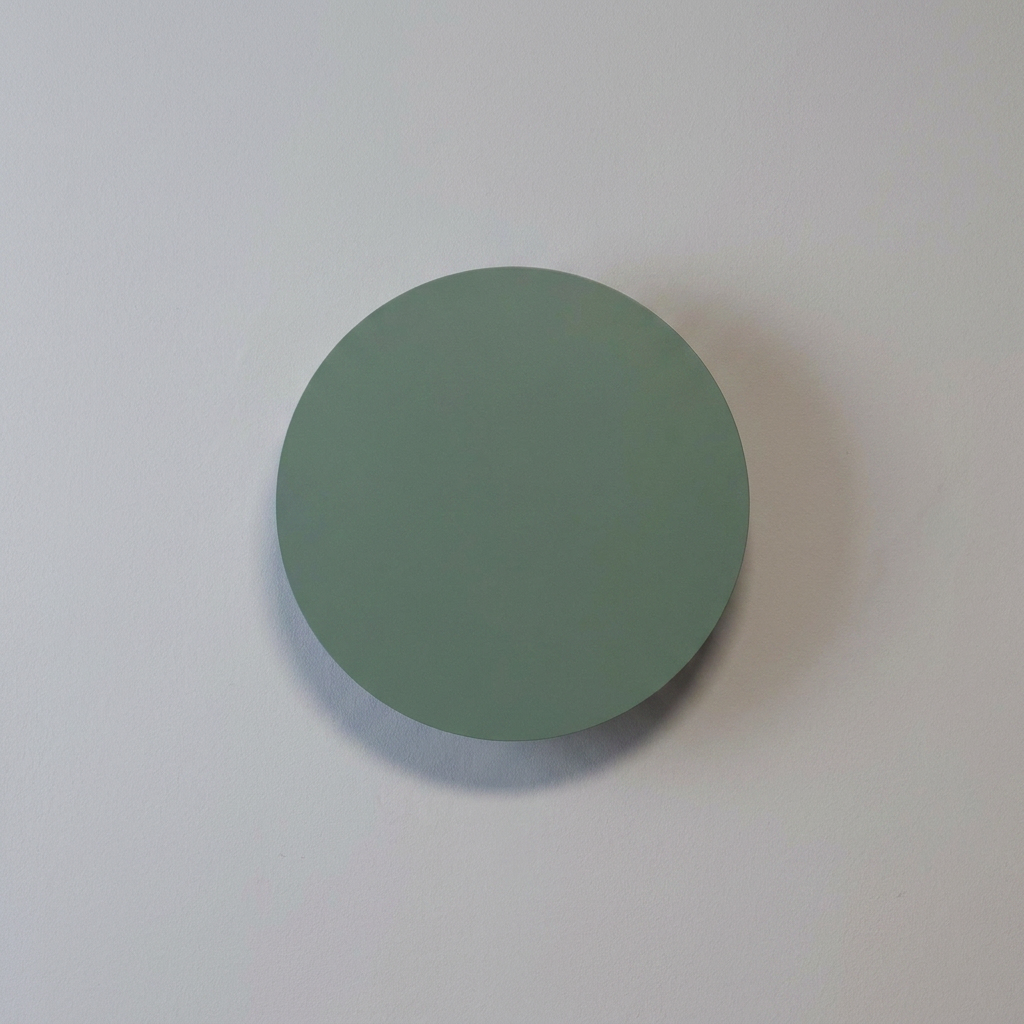 Applique murale Holar vert, éteinte sur un mur clair