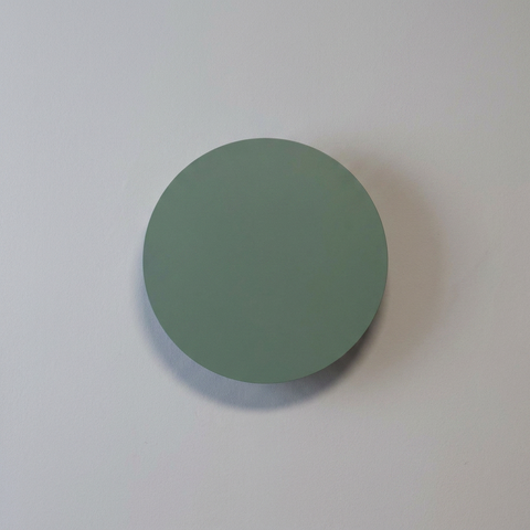 Applique murale Holar vert, éteinte sur un mur clair